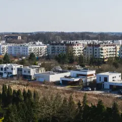 Nowa klecina z nowoczesnymi domami i blokami mieszkalnymi w tle.