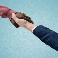Dwie dłonie, jedna ciemna, druga jasna, ściskają się. Symbolizuje to zmianę umowy z czasu nieokreślonego na określony, nowe porozumienie.