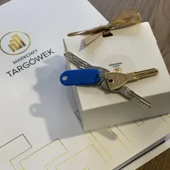 Klucze do nowego mieszkania na Markowym Targówku, zapakowane w eleganckie pudełko z logo.