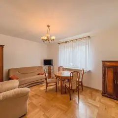 Przytulny salon z kanapą, fotelem i stołem z krzesłami. Klasyczne meble tworzą atmosferę domowego ciepła w tym aurec home.