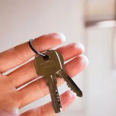 Dłoń trzyma klucze, symbolizując pytanie: czy właściciel może mieć klucze do wynajmowanego mieszkania?