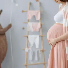 Ciężarna kobieta w pokoju dziecięcym, przygotowująca się na przyjście malucha. Czy można eksmitować kobietę w ciąży? To pytanie budzi wiele wątpliwości.