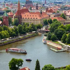 Wrocław inwestycje: malowniczy widok na Odrę z zabytkową architekturą i statkami wycieczkowymi.