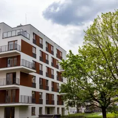Nowoczesne bloki mieszkalne w stylu riviera park, z balkonami i zielenią.